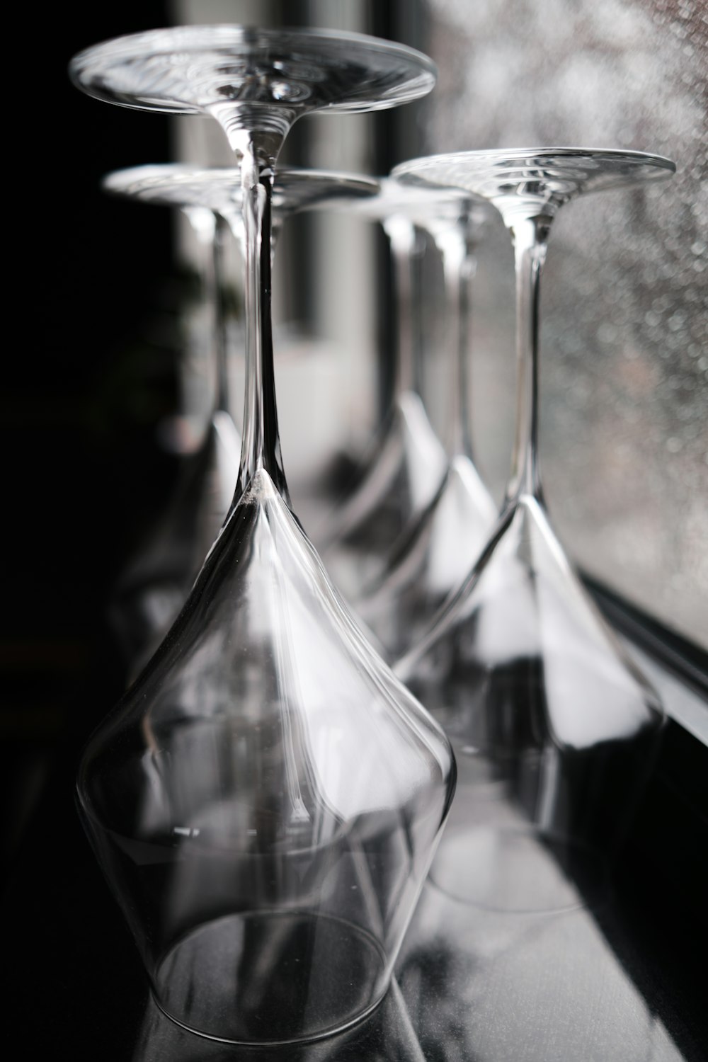 a row of wine glasses sitting on top of a window sill