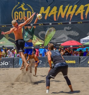 a group of men playing a game of beach volleyball