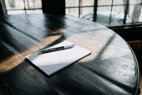 a pen sitting on top of a piece of paper on top of a wooden table