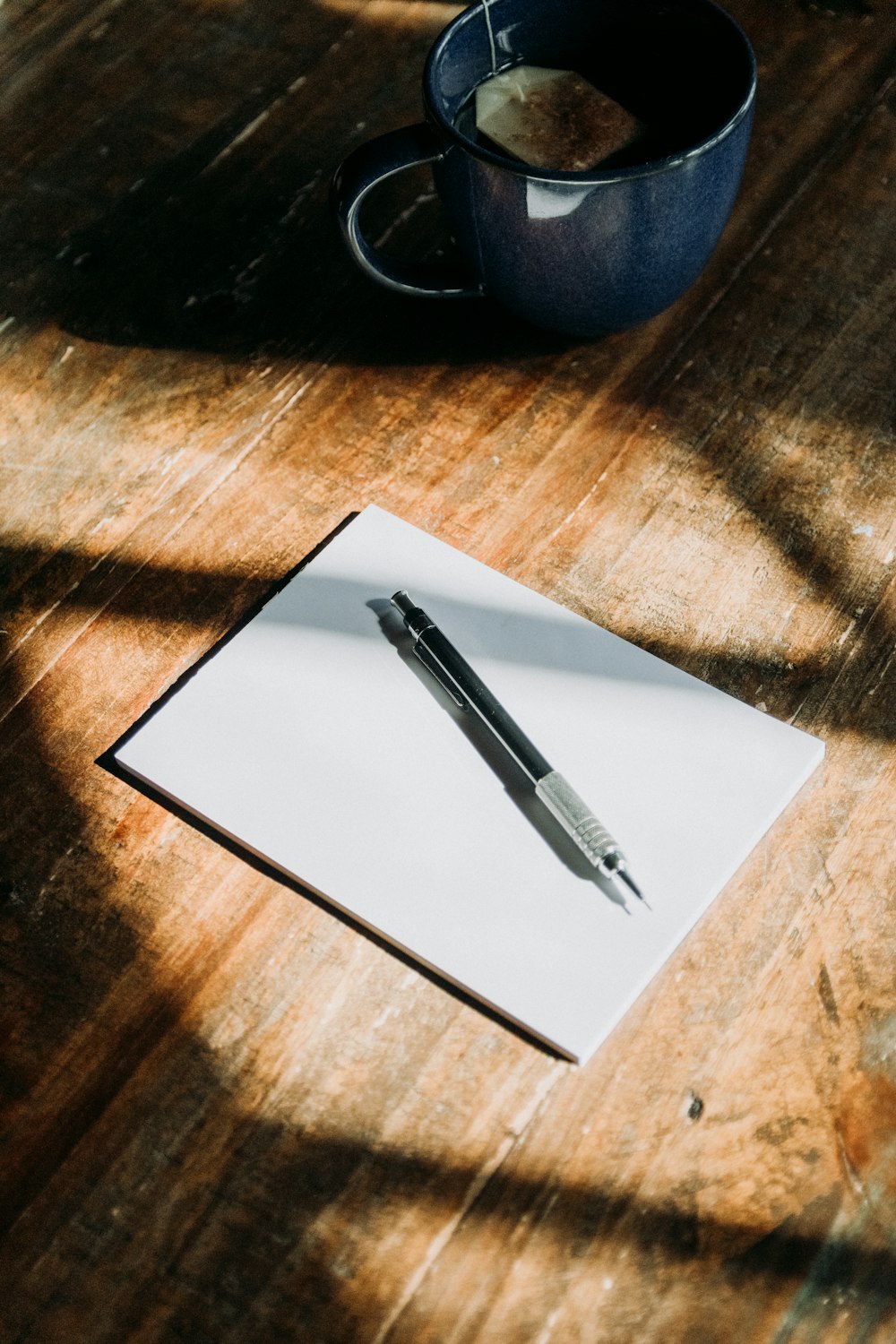 a pen sitting on top of a piece of paper next to a cup of coffee