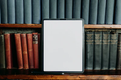 a tablet computer sitting on top of a wooden shelf