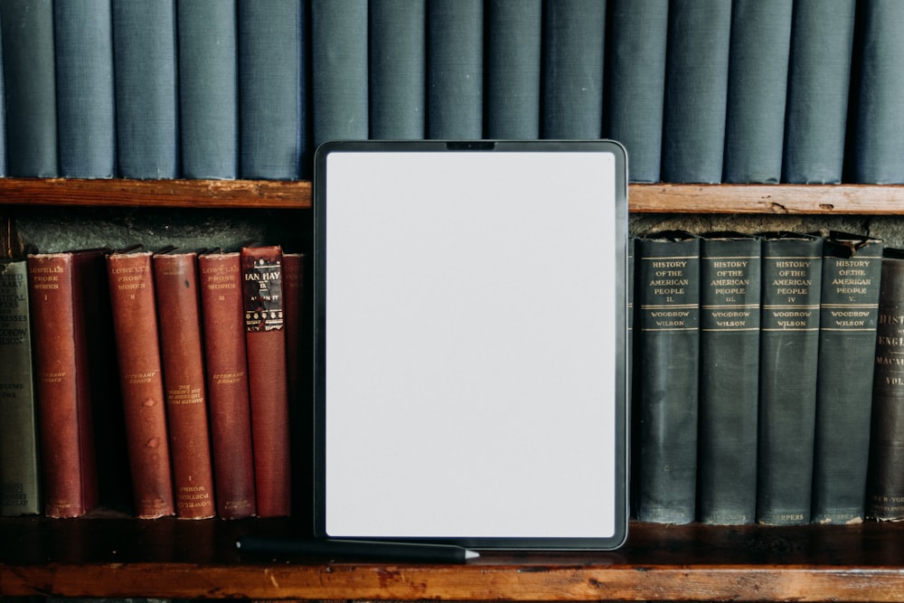 a tablet computer sitting on top of a wooden shelf