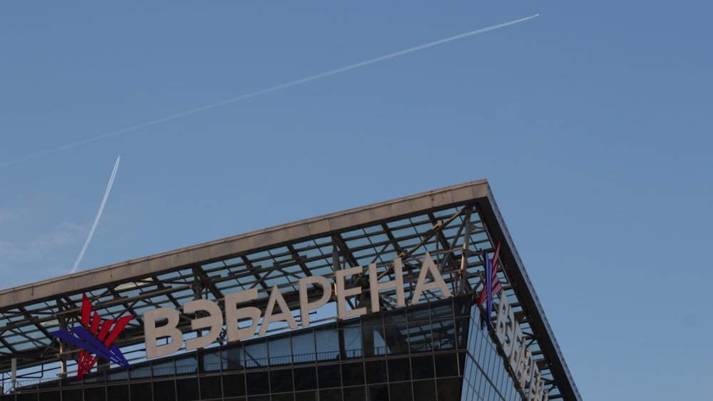 a plane flying over a building with a sign on it