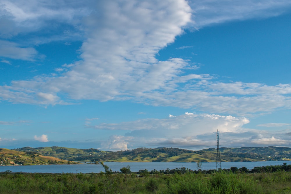 a large body of water sitting next to a lush green field