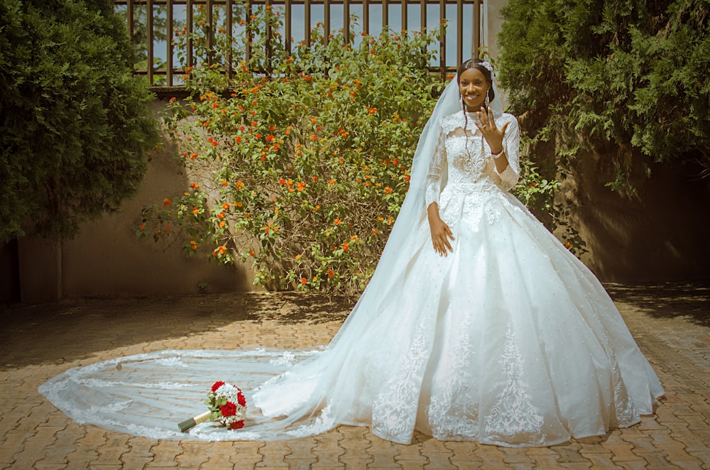 a woman in a wedding dress standing in front of a tree