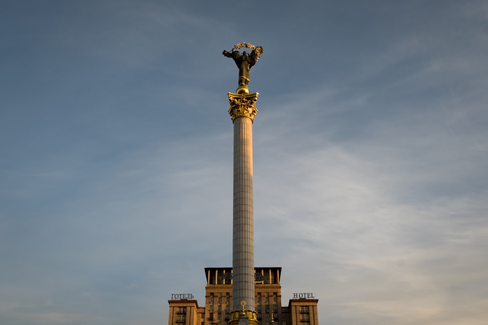 높은 건물 위에 있는 높은 황금 동상