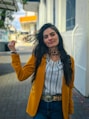 a woman in a yellow jacket and leopard print necklace