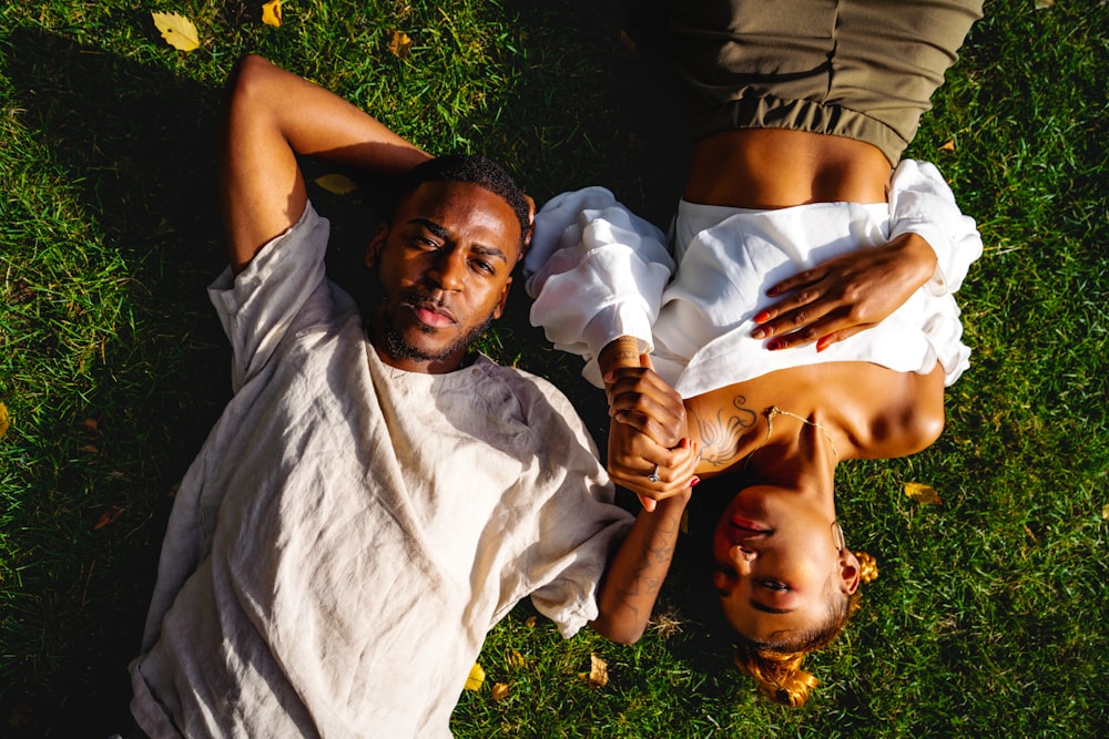 a man laying on the ground next to a woman