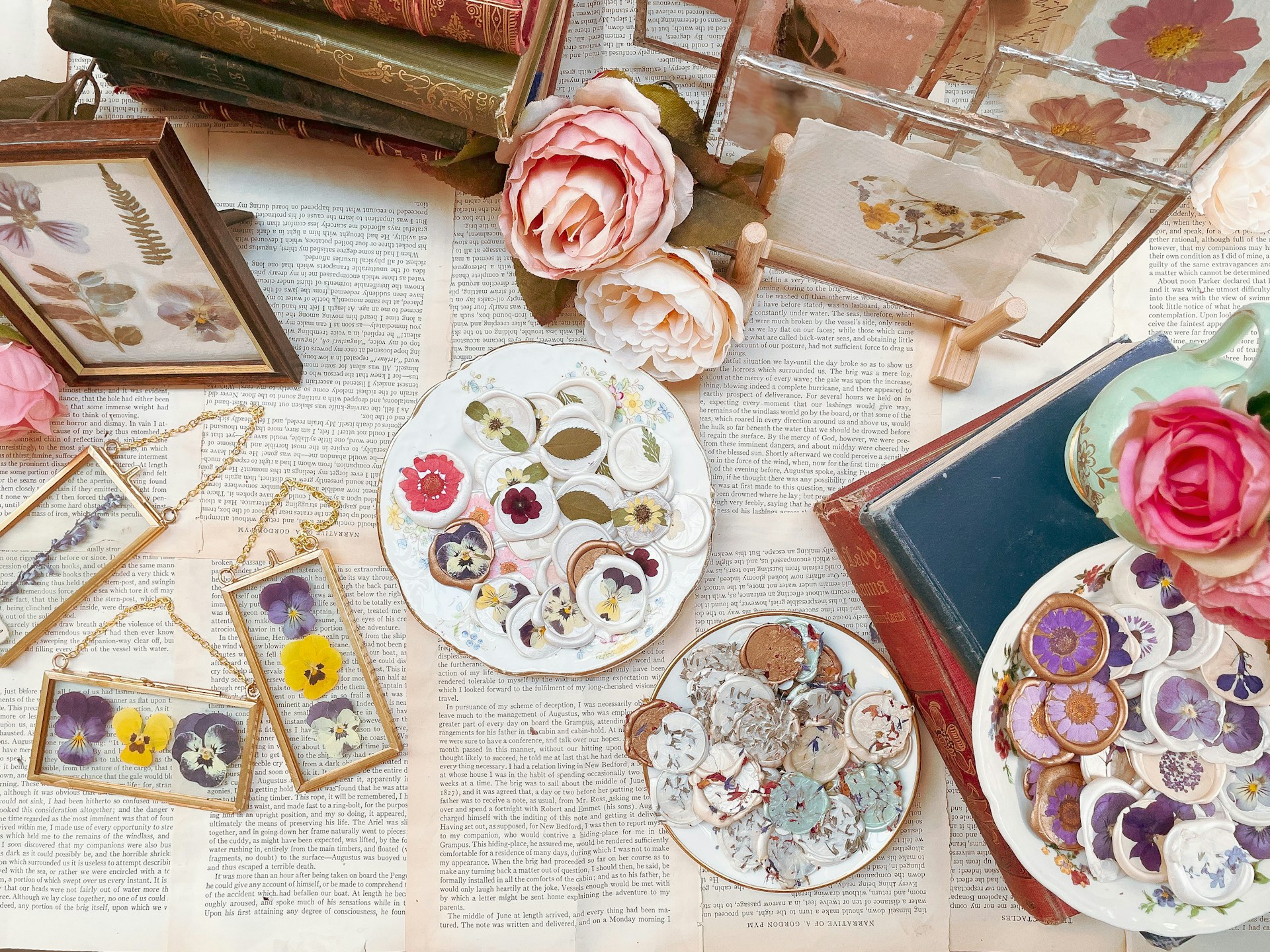 a table topped with plates and flowers next to framed pictures