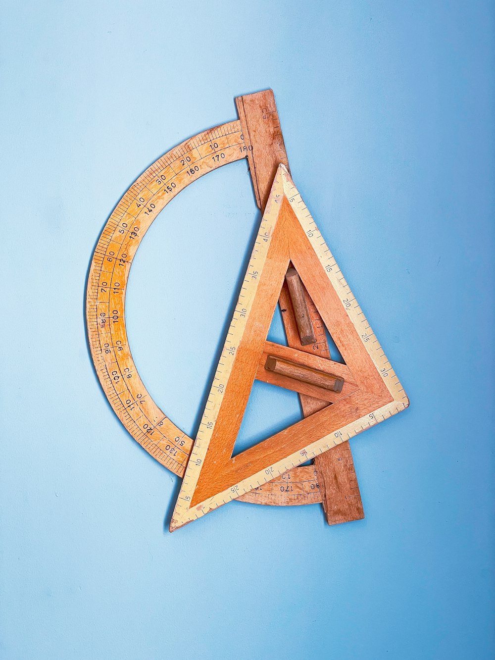 a wooden ruler and a wooden triangle on a blue background