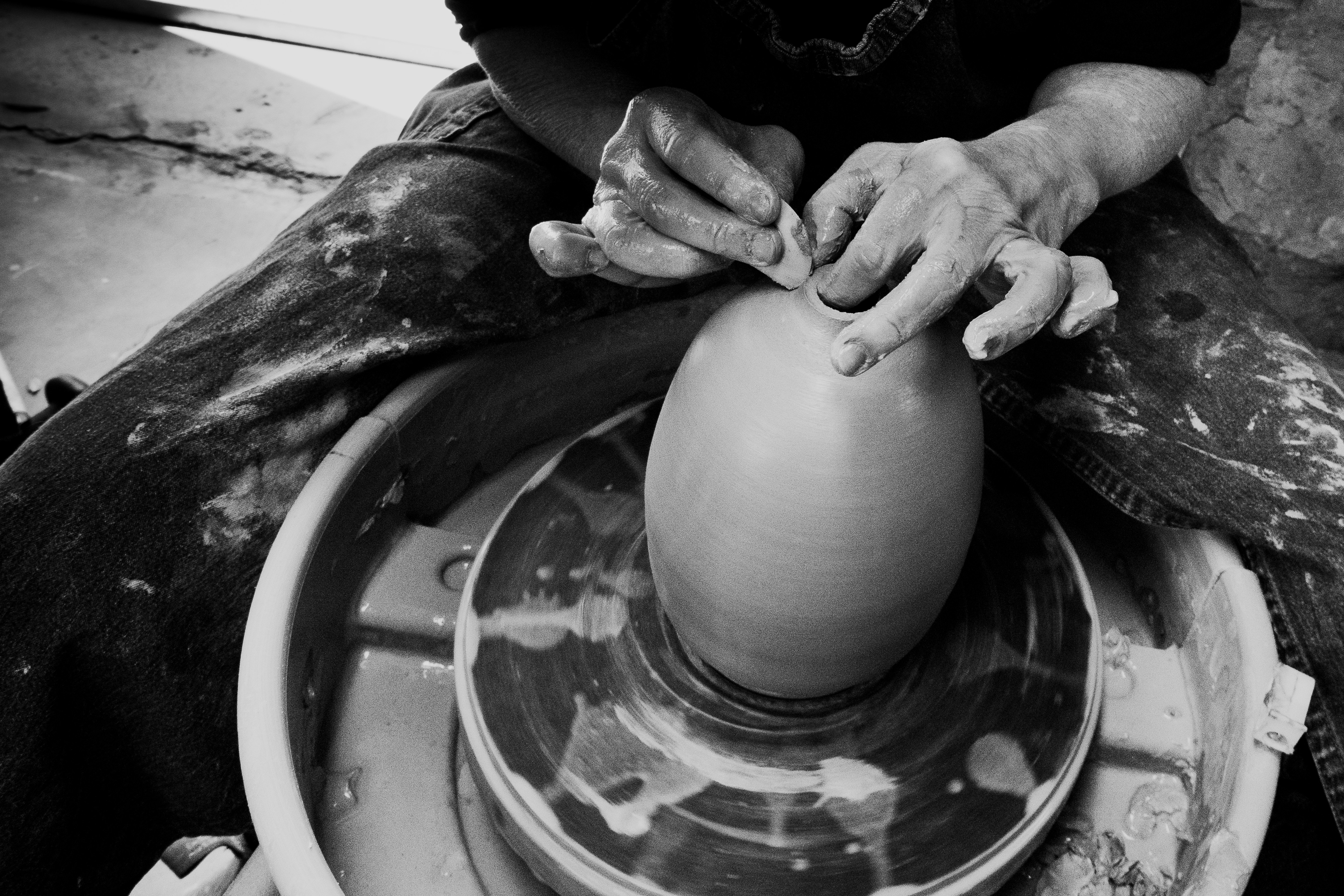 a man is making a vase out of clay