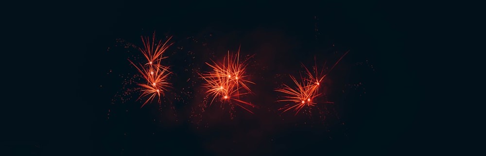 a group of red fireworks on a black background