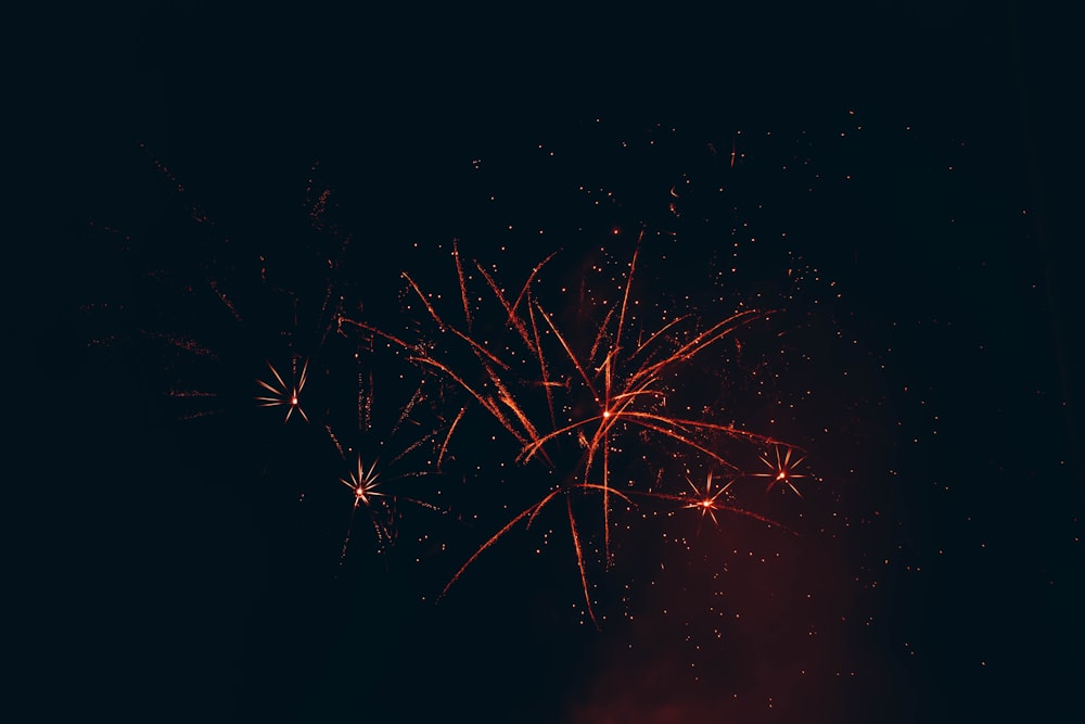 a red fireworks is lit up in the night sky