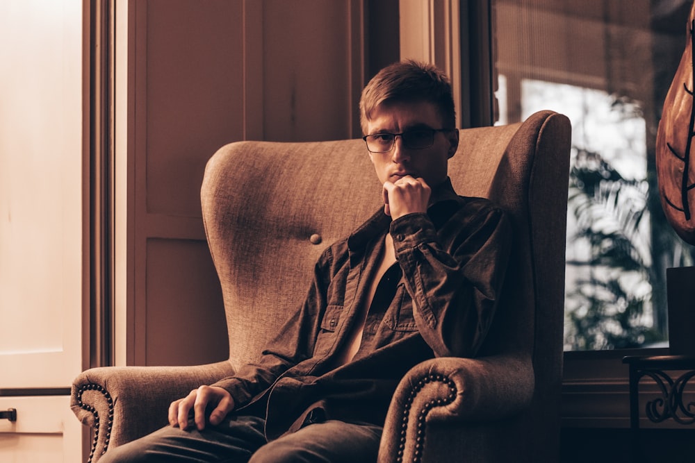 a man sitting in a chair in front of a window