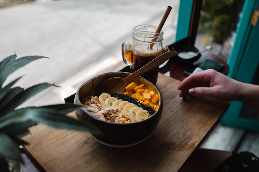 a wooden table topped with a bowl of food