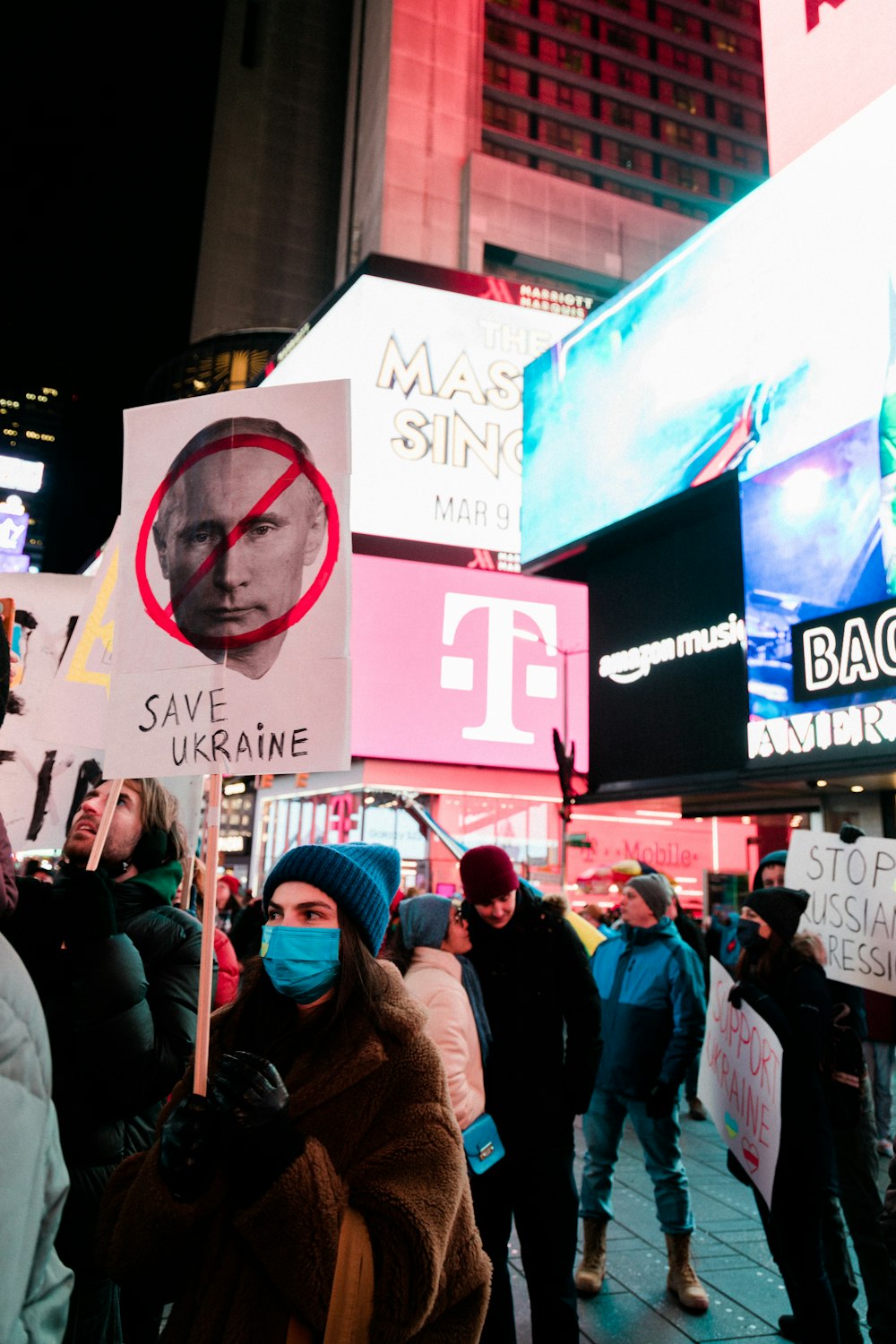 a group of people standing on a street holding signs