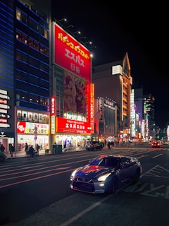 A nighttime city street scene with a Didi car displaying a bright Vibeads screen ad.