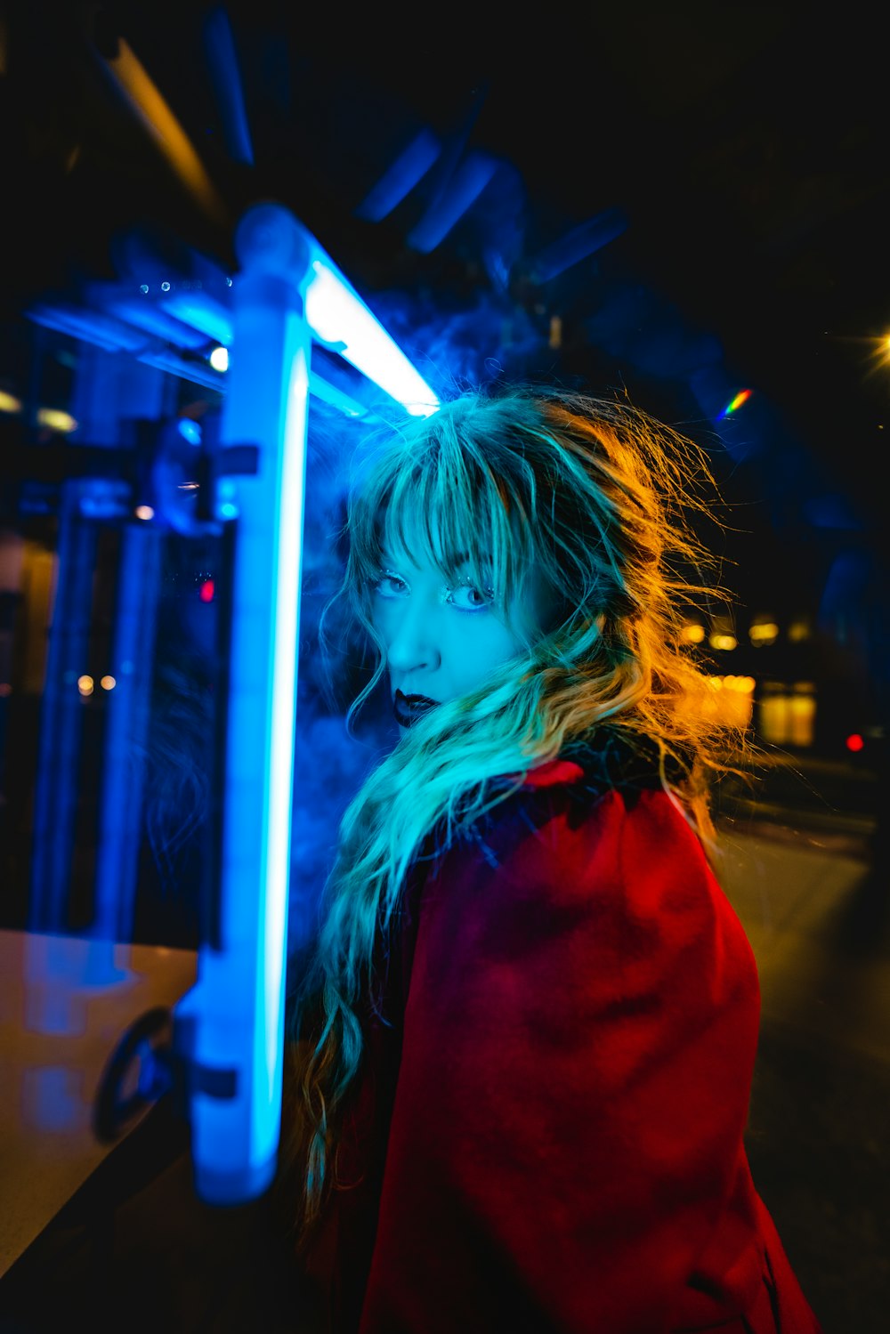 a woman standing in front of a blue light