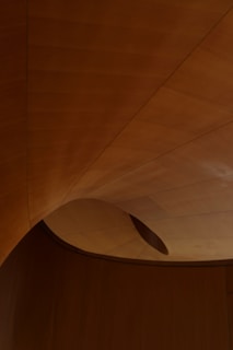 a wooden ceiling with a curved ceiling fan