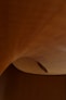a wooden ceiling with a curved ceiling fan