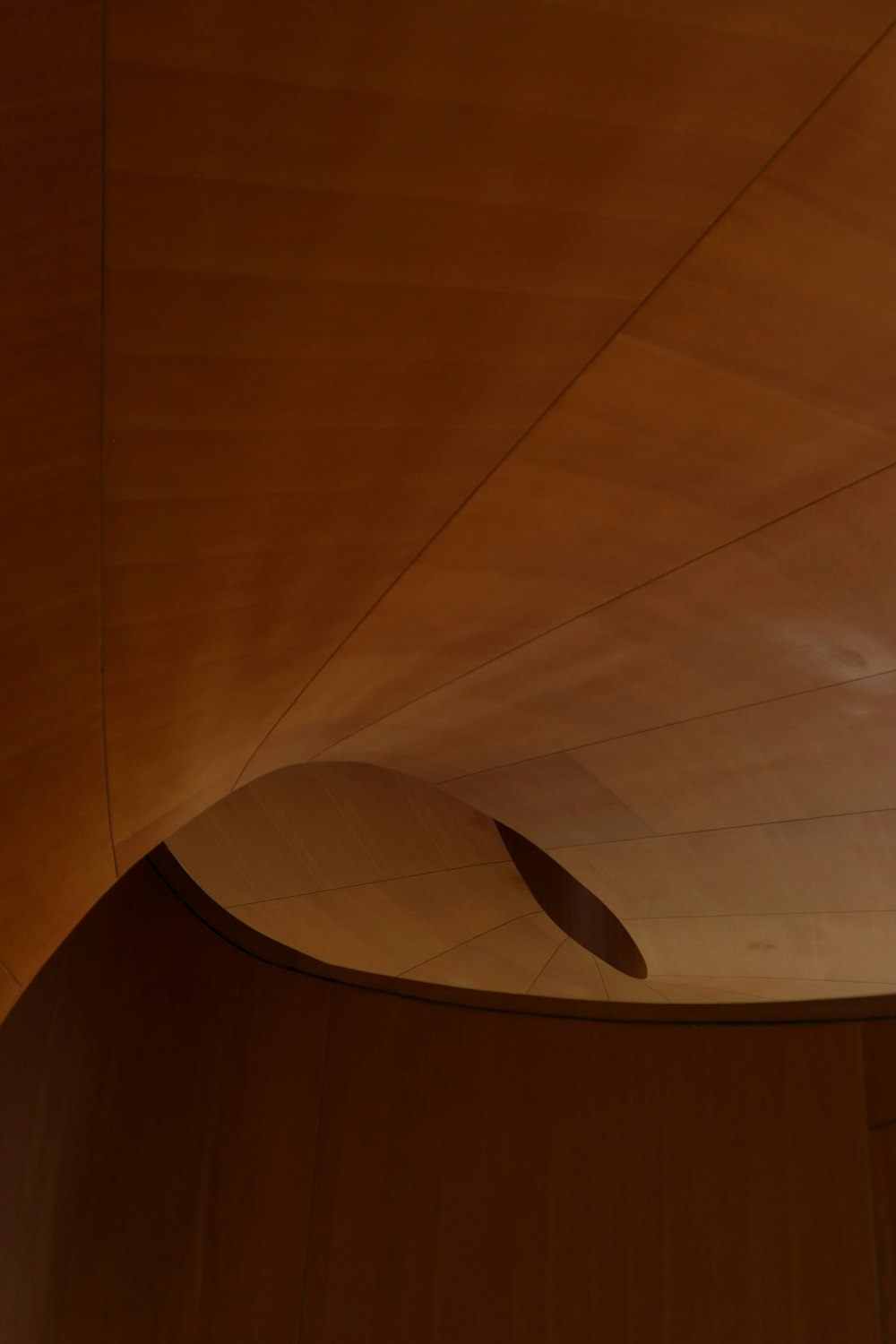 a wooden ceiling with a curved ceiling fan