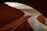 Curved, modern architecture with a polished wooden staircase gracefully winding through the interior. The soft lighting highlights the smooth textures and warm wood tones, creating an elegant and sophisticated atmosphere.