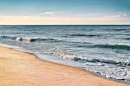 a sandy beach with waves coming in to shore