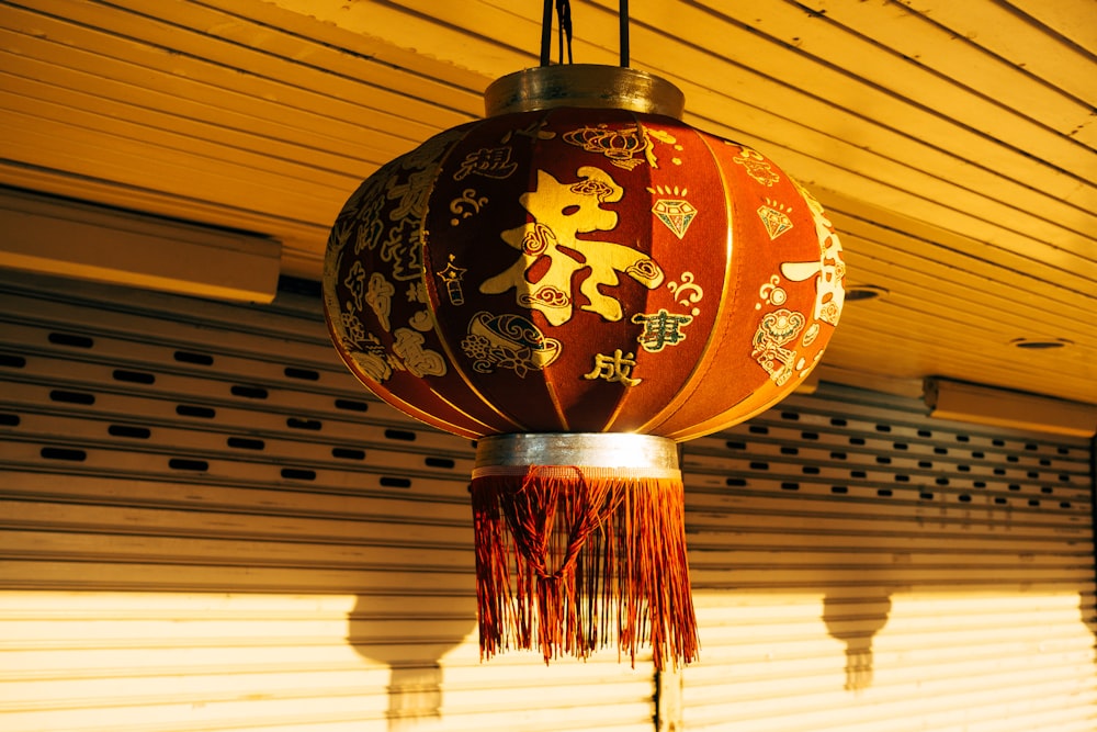 a red and gold lantern hanging from a ceiling