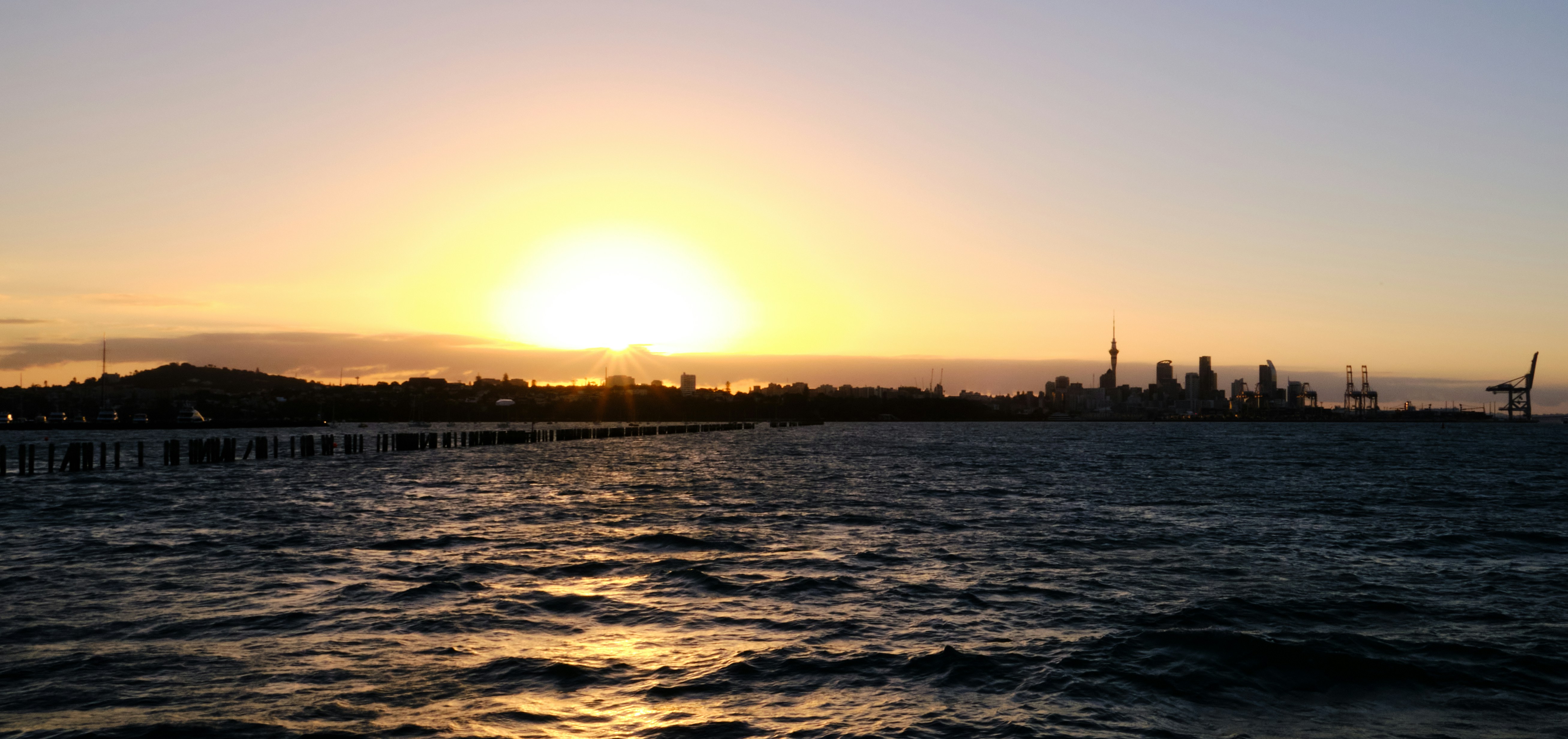 a large body of water with a sunset in the background
