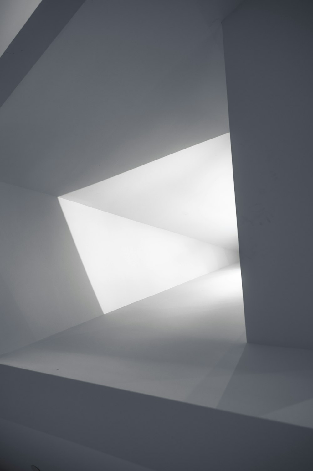a white room with a light coming through the ceiling