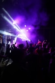 A crowd dancing joyfully under bright stage lights.