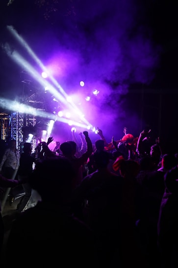 A vibrant crowd dancing under colorful lights at a trancepulse event.