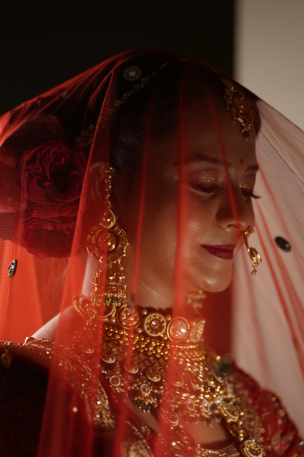 a woman wearing a veil and a red dress