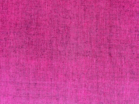 A textured fabric surface featuring a rich, deep pink color woven with visible threads creating a subtle pattern.