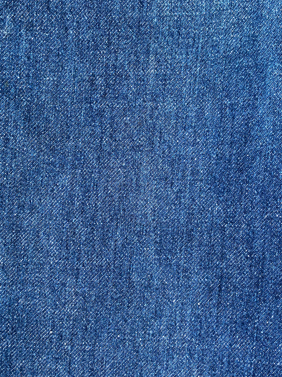 Close-up of classic indigo blue denim weave — tight cotton thread pattern