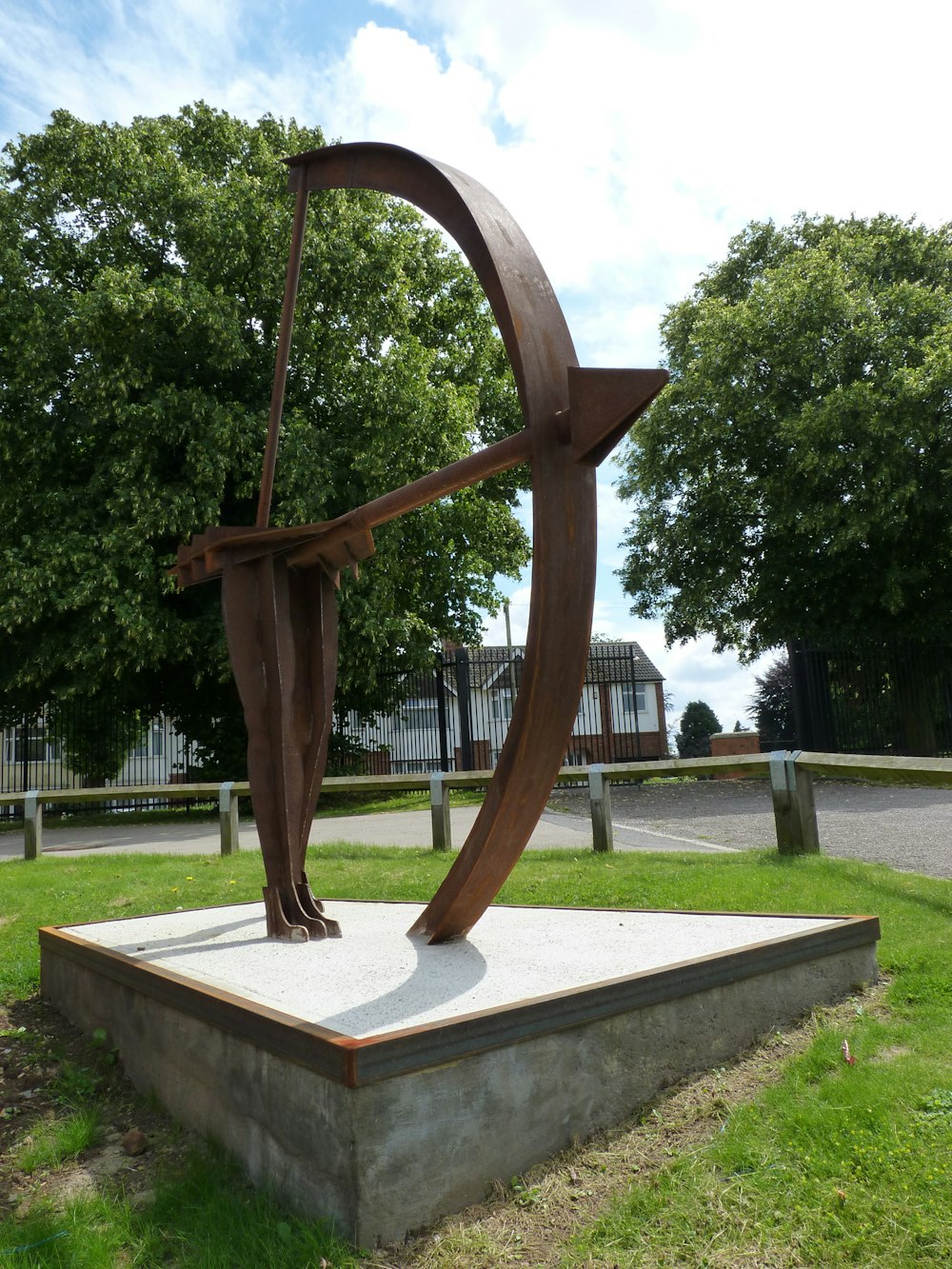 Una estatua de una persona sosteniendo un arco en un parque