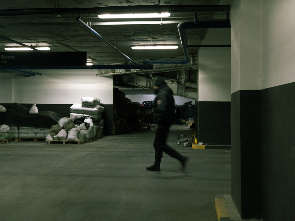 a man is walking through a parking garage