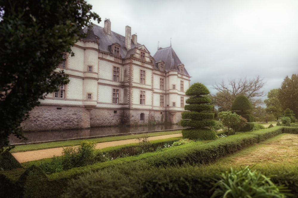 a large building with a long garden in front of it