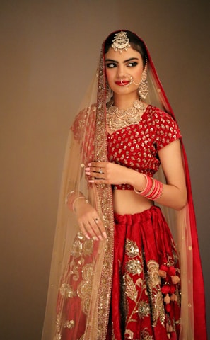 a woman in a red and gold lehenga