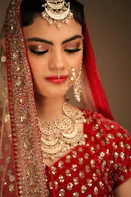 a woman wearing a red and gold bridal outfit