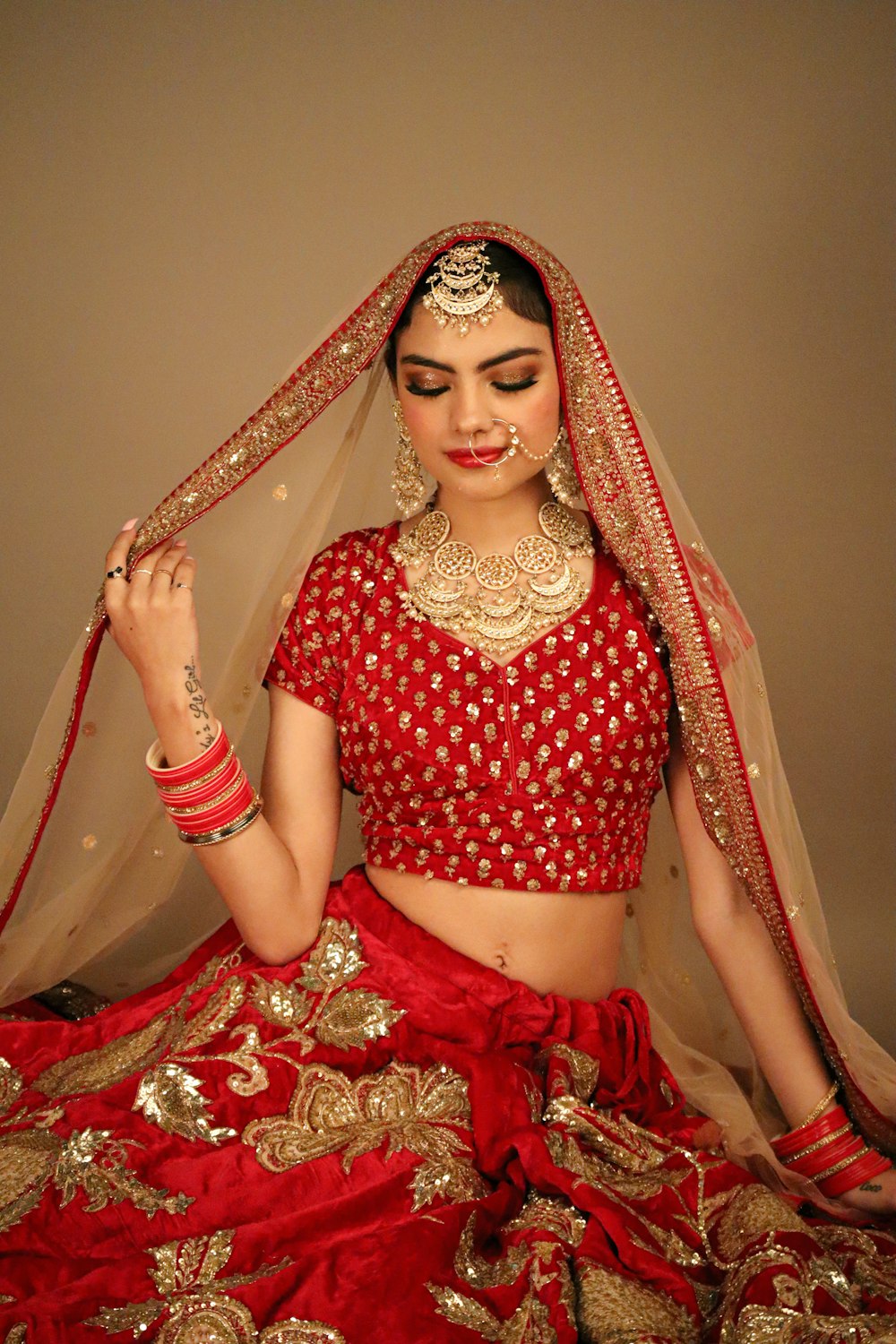 a woman in a red and gold bridal outfit