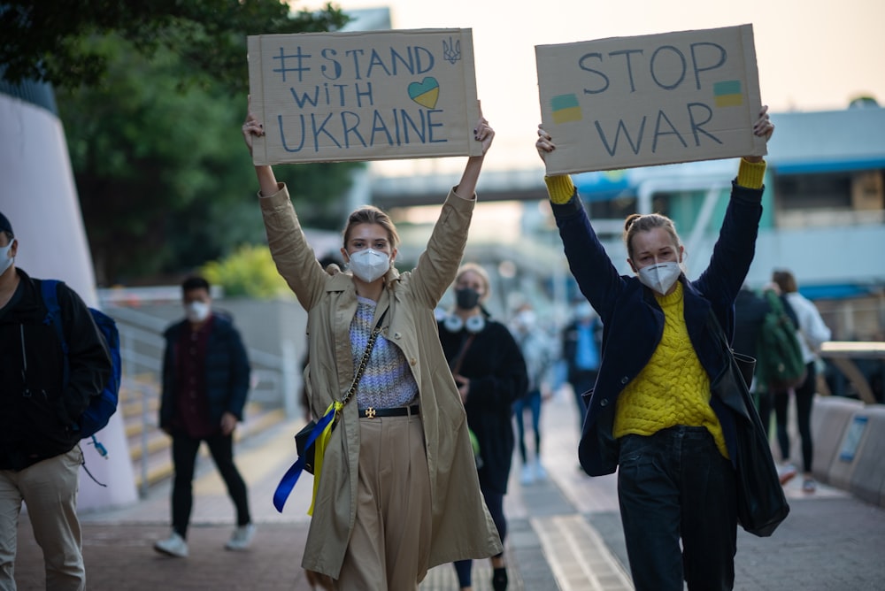 a group of people walking down a street holding signs