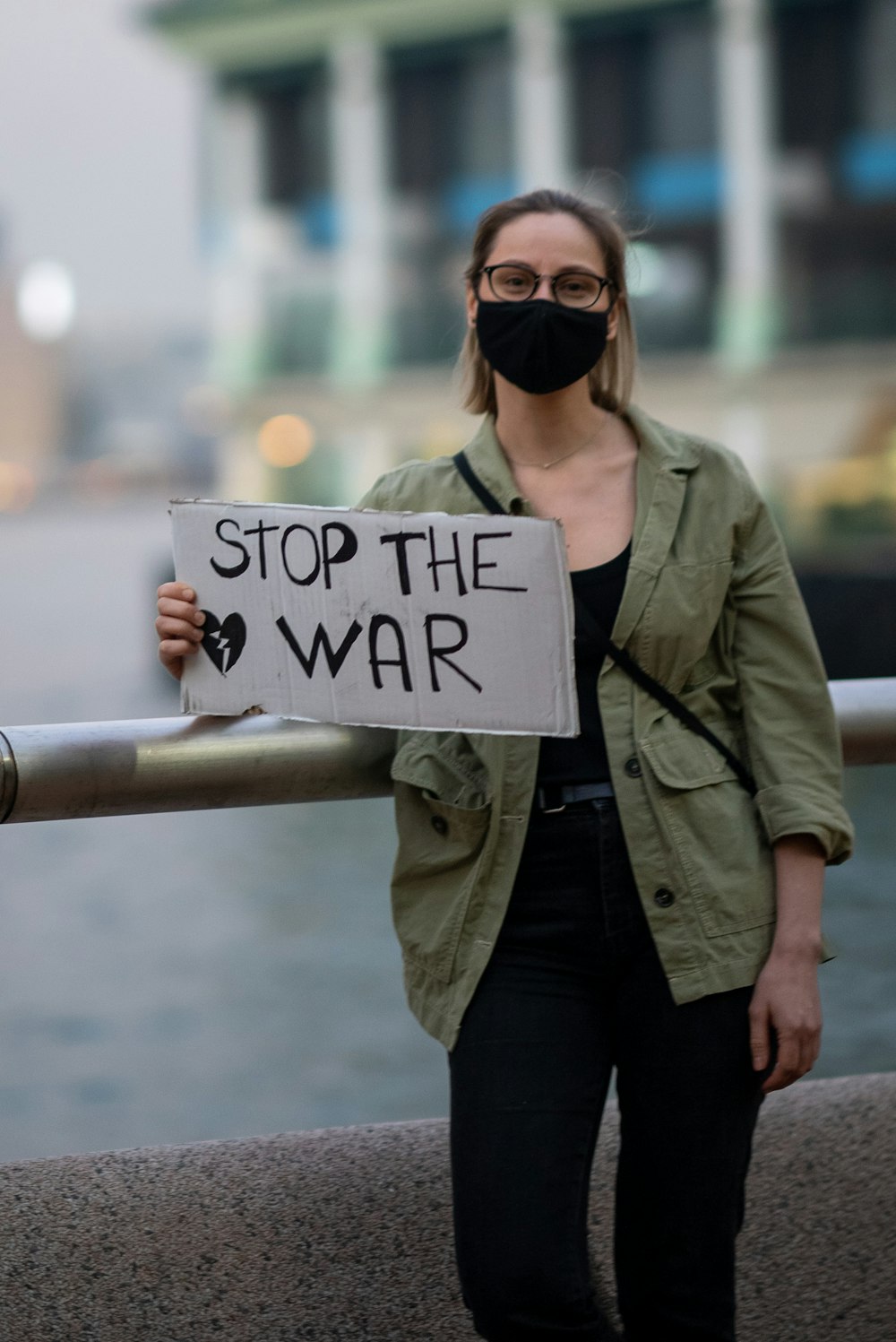 a woman holding a sign that says stop the war
