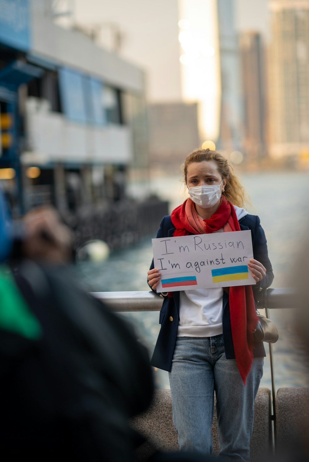 a woman wearing a face mask holding a sign