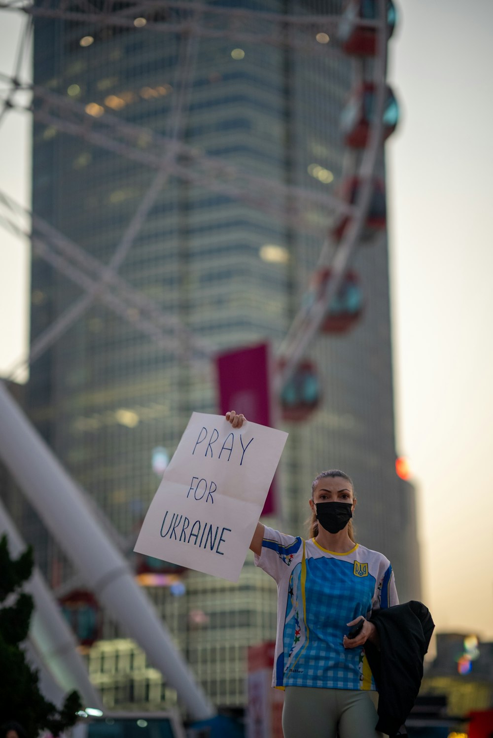 a man holding a sign that says pray for ukraine