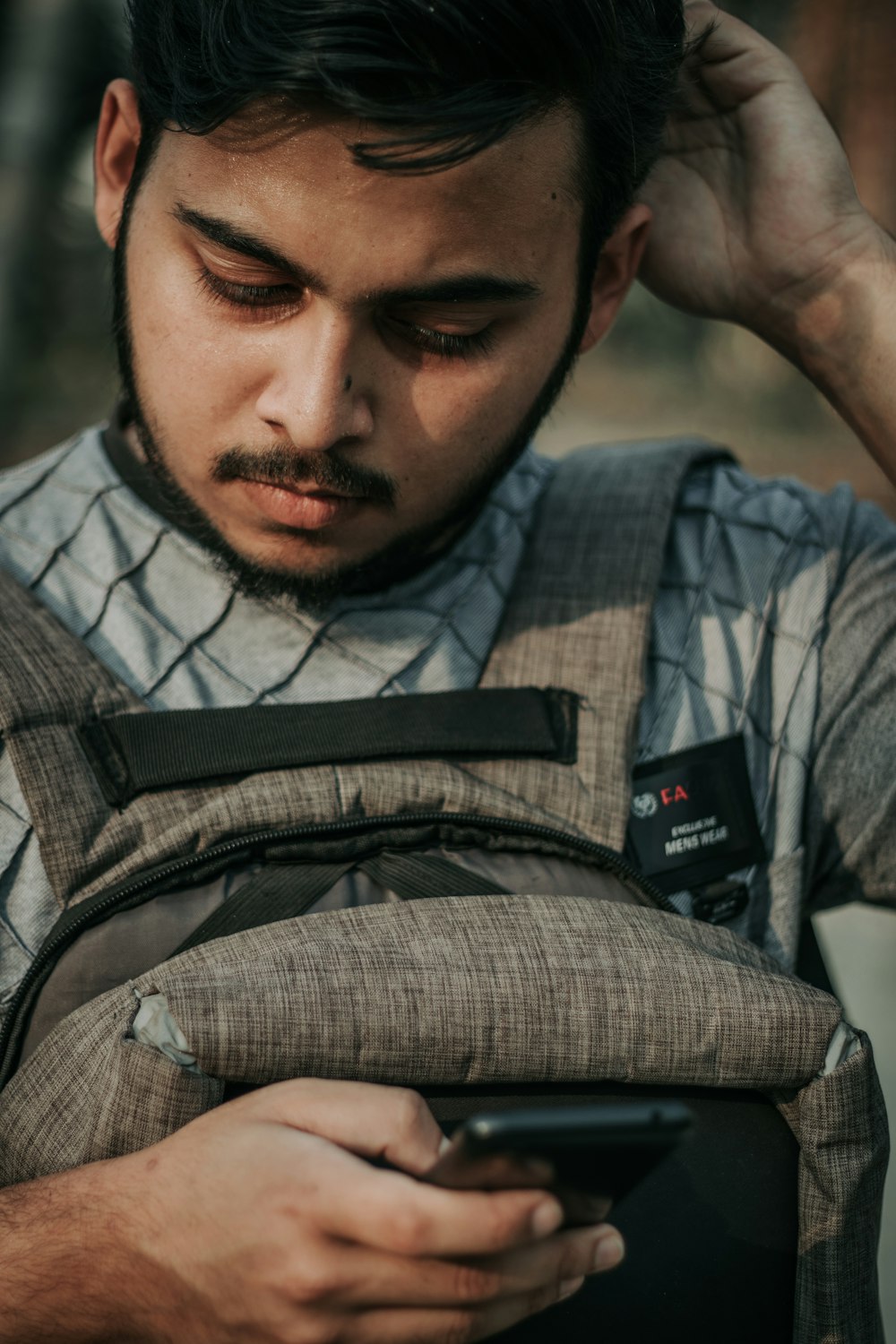 Ein Mann mit Rucksack schaut auf sein Handy