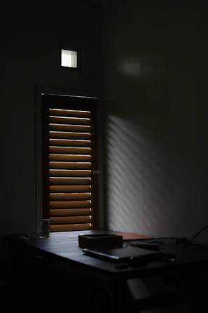 Sunlight filtering through a window onto a wooden table with design sketches and tools.