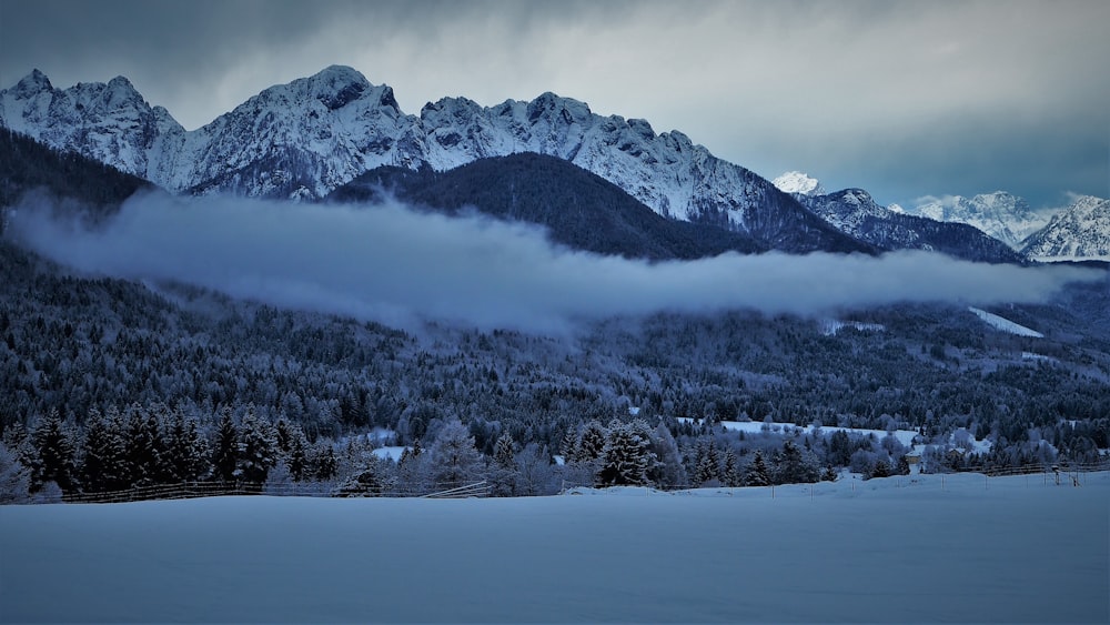 a mountain range covered in snow and clouds