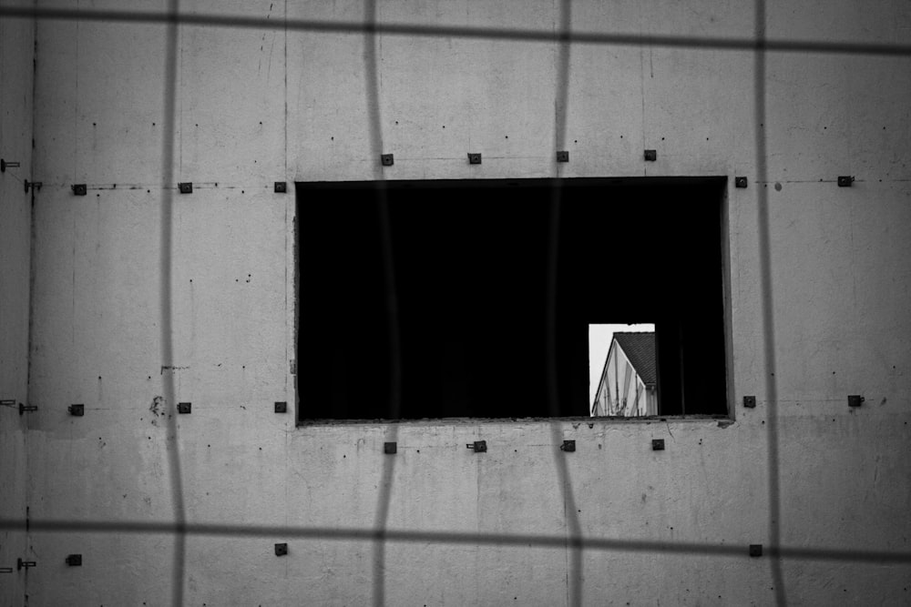 une photo en noir et blanc d’une fenêtre dans un bâtiment