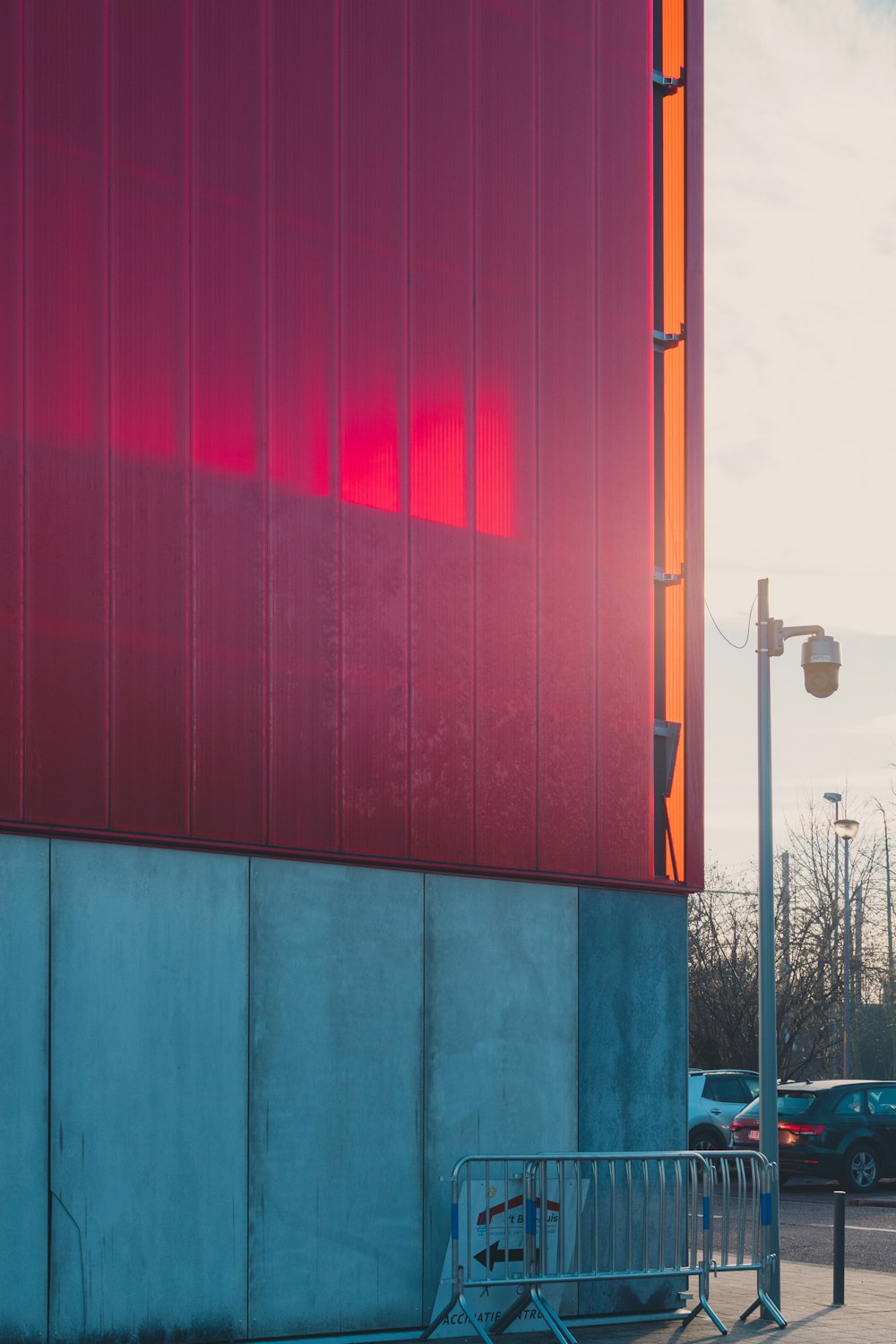 um edifício vermelho com uma cerca de metal ao lado dele